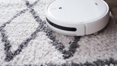 Otomatik robot elektrikli süpürge hareket ediyor ve halıyı temizliyor. Akıllı ev teknolojileri.