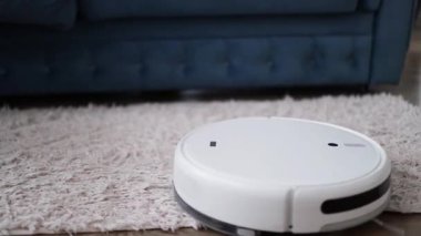 Otomatik robot elektrikli süpürge hareket ediyor ve halıyı temizliyor. Akıllı ev teknolojileri.