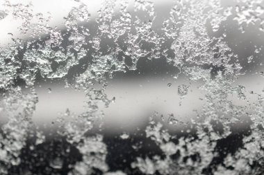 Dışarıya park edilmiş donmuş bir araba, kışın erken soğuğu. Otomobil Penceresinden Kayan Eriyen Kar Parçacıkları.