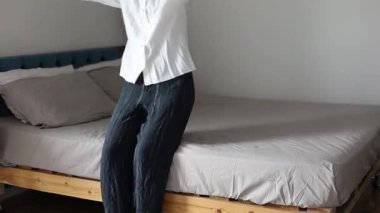 Sıcak bir yatağa düşen, yorucu bir günün ardından dinlenen, stresi azaltan, evdeki enerjiyi geri getiren genç bir kadın. Yumuşak Yatak, Rahatlatıcı Dinlenme Koşulları, Sağlıklı Yaşam. Rahatlama Konsepti.