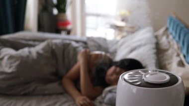 Yatak odasında hava nemlendiricisiyle uyumak, daha iyi bir uyku için nemi arttırmak..