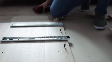 Profesyonel İşçi Mobilya Toplayıcı, Kabine Çekmecesi için Kaydırma Mekanizması Operasyonunu Kontrol Ediyor. Yakın plan. Montaj ve Mobilya Satışı.