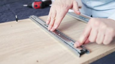 Profesyonel İşçi Mobilya Toplayıcı, Kabine Çekmecesi için Kaydırma Mekanizması Operasyonunu Kontrol Ediyor. Yakın plan. Montaj ve Mobilya Satışı.