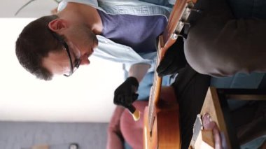 Gitar tamiri, akustik gitarı temizlemek, panoyu silmek için temiz bez, yakın plan....