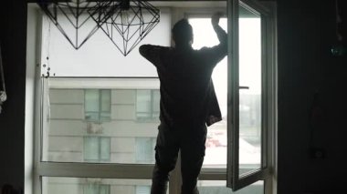 Konut alanındaki pencerelere cibinlik yerleştiriliyor. Genç adam odaya cibinlik yerleştiriyor..