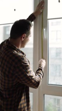 Konut alanındaki pencerelere cibinlik yerleştiriliyor. Genç adam odaya cibinlik yerleştiriyor..