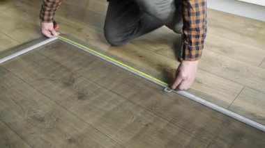 Pencere örgü ören ellere yakın çekim. Parmaklar ağ ile çerçeve kanalına basar. Bulanık arka plan, kapalı mekan ayarlarını gösteriyor. Ekran malzemelerinin korunması üzerine titiz ve detaylı çalışmalara odaklanın