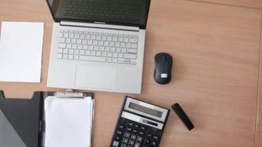 Ofisteki modern dizüstü bilgisayarda daktilo yazan Asyalı iş kadını. Yakın plan. O, ofisteki masada vergileri saymak için bir dizüstü bilgisayar ve hesap makinesi kullanıyor. İş denetimi ve finans işindeki kadın