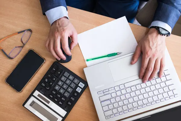 Modern ofiste hesap makinesi kullanan bir iş adamı. İş analizi - hesap makinesi, kağıt, iş raporu ve analist eli, üst görünüm.