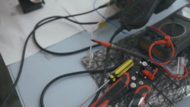 Teknisyen elleri lehimleme demiriyle devre kartlarını onarıyor. Mikro elektronik bileşenlerin ve hassas lehimleme işleminin aşırı yakın çekimi. Donanım tanılama kavramı