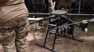 Bir asker tarlada insansız hava aracı kullanıyor. İnsansız hava araçlarının çarpışma kullanımı. Orduda modern teknolojileri kullanma kavramı. Ordu insansız hava aracı kullanıyor. Bombalı sivil uçak.