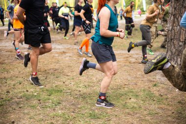 Kiev, Ukrayna - Mayıs 2025: Bir orman macerası parkında engelli yarış sırasında grup açık hava fitness aktivitesi.