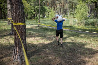 Ukraynalı sporcu erkek Ukrayna 'nın başkenti Kyiv' deki yarışmada kum torbası taşıyor..