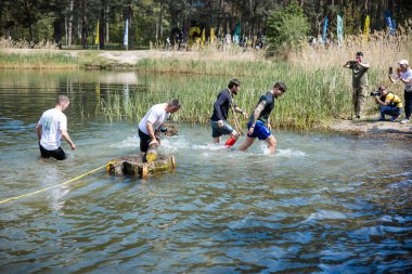 Kiev, Ukrayna - Mayıs 2025: Bir orman macerası parkında engelli yarış sırasında grup açık hava fitness aktivitesi.