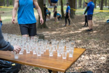 Yorgun spor müsabakalarına katılanlar bir bardak su içiyorlar. Koşucular su içer, sporcular suya koşar..