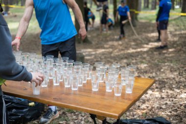 Yorgun spor müsabakalarına katılanlar bir bardak su içiyorlar. Koşucular su içer, sporcular suya koşar..