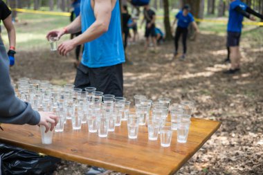 Yorgun spor müsabakalarına katılanlar bir bardak su içiyorlar. Koşucular su içer, sporcular suya koşar..