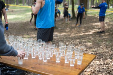 Yorgun spor müsabakalarına katılanlar bir bardak su içiyorlar. Koşucular su içer, sporcular suya koşar..