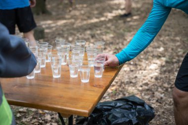 Yorgun spor müsabakalarına katılanlar bir bardak su içiyorlar. Koşucular su içer, sporcular suya koşar..