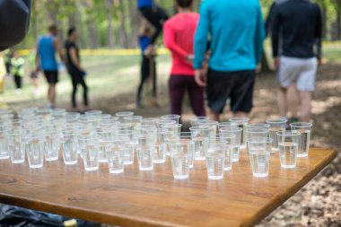 Yorgun spor müsabakalarına katılanlar bir bardak su içiyorlar. Koşucular su içer, sporcular suya koşar..