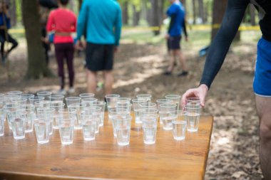 Yorgun spor müsabakalarına katılanlar bir bardak su içiyorlar. Koşucular su içer, sporcular suya koşar..