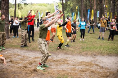 Kiev, Ukrayna - Mayıs 2025: Bir orman macerası parkında engelli yarış sırasında grup açık hava fitness aktivitesi.