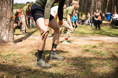 Kiev, Ukrayna - Mayıs 2025: Bir orman macerası parkında engelli yarış sırasında grup açık hava fitness aktivitesi.