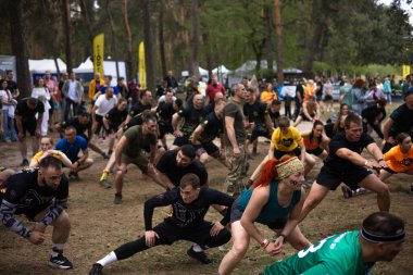 Kiev, Ukrayna - Mayıs 2025: Bir orman macerası parkında engelli yarış sırasında grup açık hava fitness aktivitesi.