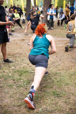 Kiev, Ukrayna - Mayıs 2025: Bir orman macerası parkında engelli yarış sırasında grup açık hava fitness aktivitesi.