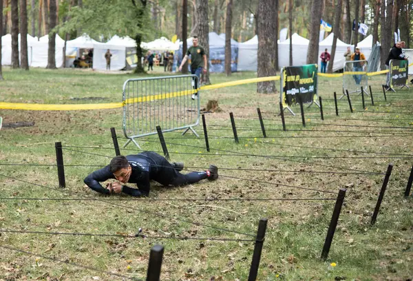 Açık hava engelli parkurunda ağ altında sürünen sporcu adam animasyona katılıyor. meydan okuma, ırk, fitness, takım çalışması konsepti.