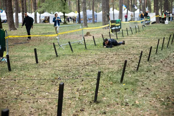 Açık hava engelli parkurunda ağ altında sürünen sporcu adam animasyona katılıyor. meydan okuma, ırk, fitness, takım çalışması konsepti.