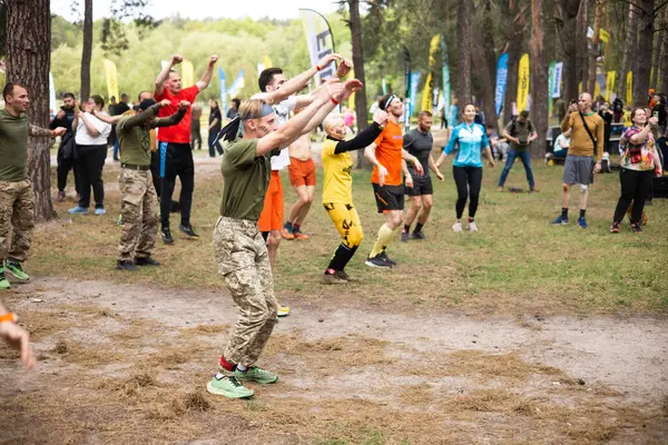 Kiev, Ukrayna - Mayıs 2025: Bir orman macerası parkında engelli yarış sırasında grup açık hava fitness aktivitesi.