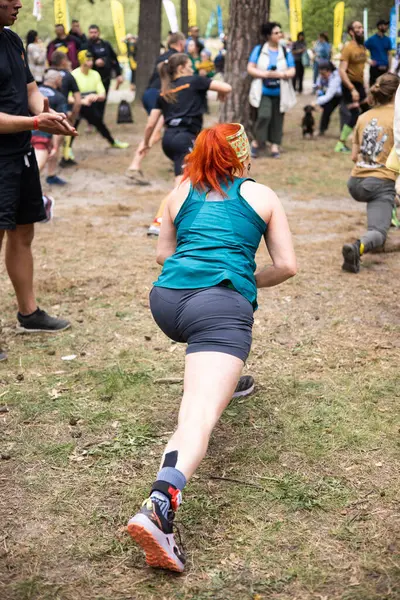 Kiev, Ukrayna - Mayıs 2025: Bir orman macerası parkında engelli yarış sırasında grup açık hava fitness aktivitesi.