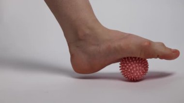 Kadın kas ağrısı ve stresten dolayı ayak masajı topuyla antrenman yapıyor. Sıkı çalışma gününden sonra rahatlama masajı. 