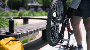 Yakından tanınmayan bisikletçi erkek. Şehrin caddesinde ayak dinlenme yeri.. 