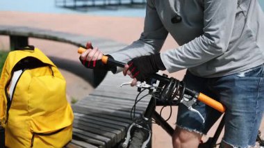 Bisiklet tamircisinin elleri yıpranmış gidonları değiştiriyor. Bisiklet tamiri, teşhis ve bisiklet bileşenlerinin ayarlanması. Çevre taşımacılığının elle bakımı