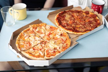 Yemek servisi. Restorandan yemek sipariş etmek. Evde aile yemeği. Pepperoni ve peynir sosu. Karton kutu. Cuma partisi. Rahatlatıcı yemek..