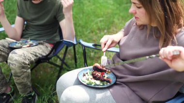 Barbekü bitti, anne ve oğlu ormanda oturmuş, tavuk kebabını yiyorlar.. 