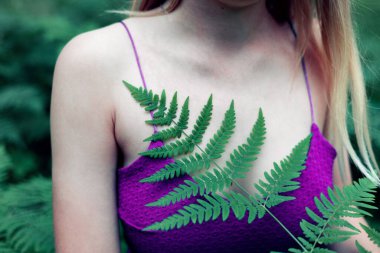 Yaz Park Ormanında Eğreltiotu Yaprağı Tutan Genç Kız. Kadın El 'in Yakın Çekimi. Doğa Konsepti, Çevre Bakımı. Yaz sezonu.