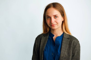 Kafkas kökenli, takım elbiseli, beyaz arka planda kameraya bakan bir öğrencinin portresi..