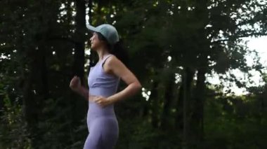 Parkta koşan atletik kadınların yan görünüşü, spor için ideal, açık hava egzersizleri, ve yeşil şehir parkı ortamında aktif yaşam tarzı içeriği.