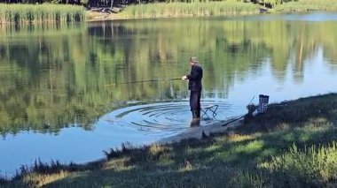 İnsan balıkçı, gölün sularına balıkçı oltası atar..