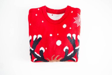 Beyaz arka planda katlanmış kırmızı örülmüş Noel süveteri. Örülmüş kış kazağı boş fotokopi alanı. Tatil dekorasyonu. Mevsimlik kıyafetler.