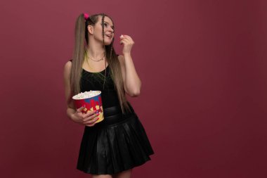 Etkilenmiş kadının portresi kırmızı arka planda izole edilmiş patlamış mısır.