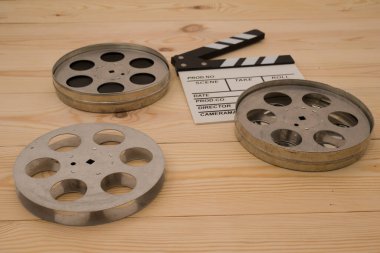 Film kamerası tahtası ve ahşap masa üzerinde yuvarlanıyor.