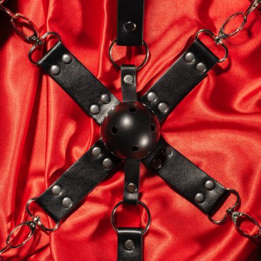BDSM kıyafeti üst görünümü. Esaret ve kırmızı keten üzerinde gag topu yakın. Yetişkin Seks Oyunları. Sapıkça yaşam tarzı. -görüntü