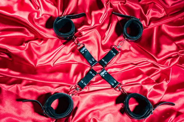 BDSM kıyafeti üst görünümü. Kırmızı keten üzerinde esaret geçti. Yetişkin Seks Oyunları. Sapıkça yaşam tarzı. -görüntü