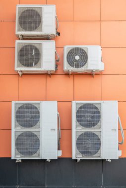 Açık hava turuncu duvarına klima kompresörü yerleştirildi