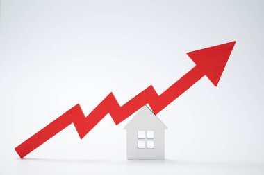 Kırmızı bir ok ve ev. Artan gayrimenkul fiyatları kavramı