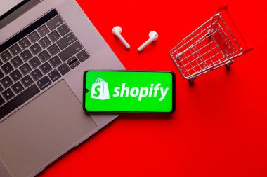 Kyoto Şehri, Japonya - 31 Temmuz 2023: Kırmızı arka planda Shopify logosu olan Apple iPhone